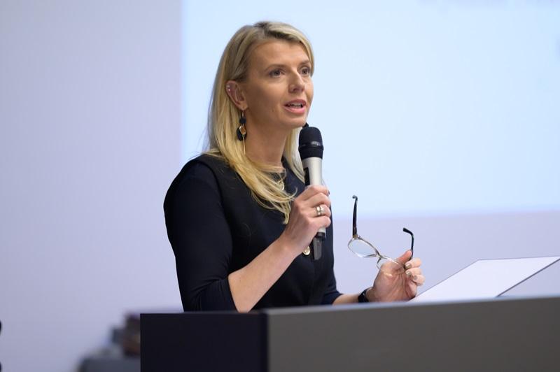 Prowadząca konferencję na tle wyświetlanej prezentacji