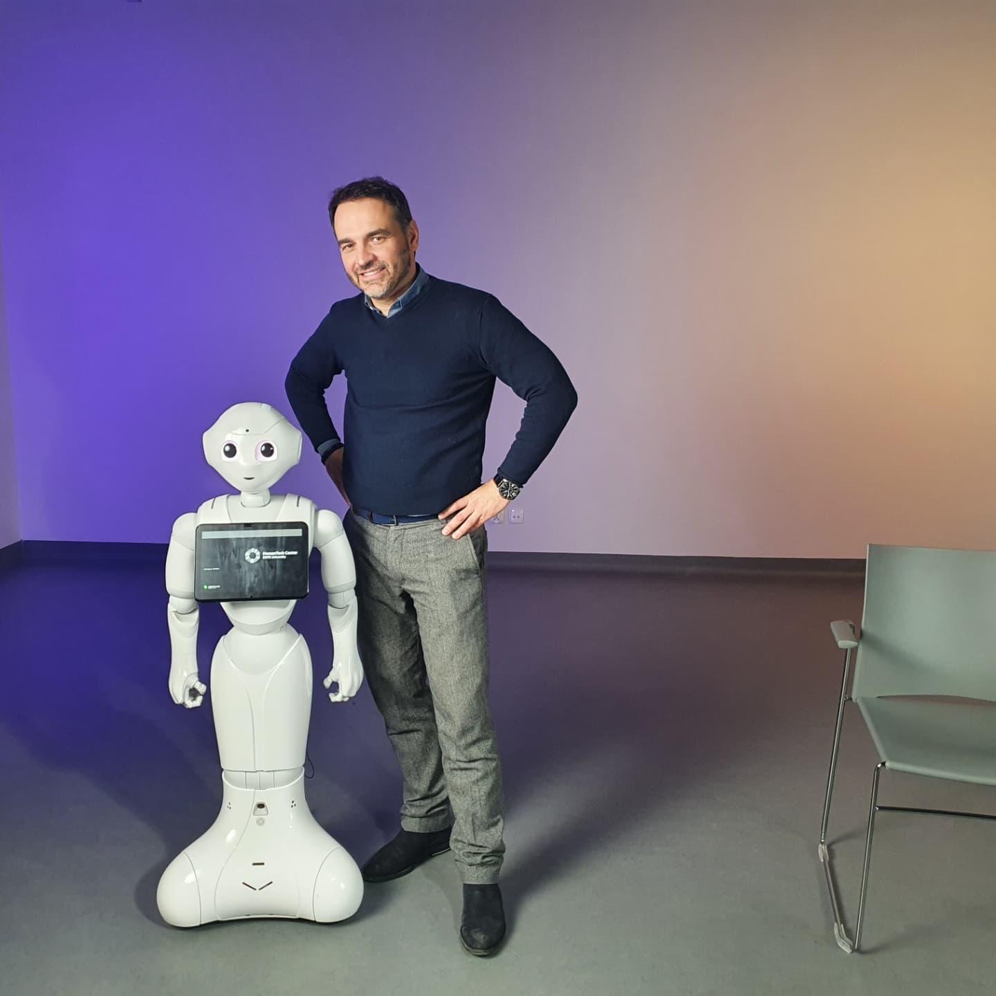 zdjęcie przedstawia dr Konrada Maja z humanoidalnym robotem, który brał udział w badaniu