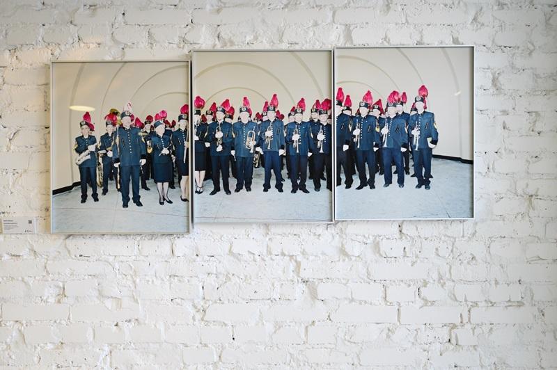Fotografia autorstwa Rafała Milacha, przedstawiająca dużą grupę ubranych na galowo górników w czapkach z czerwonymi piórami.