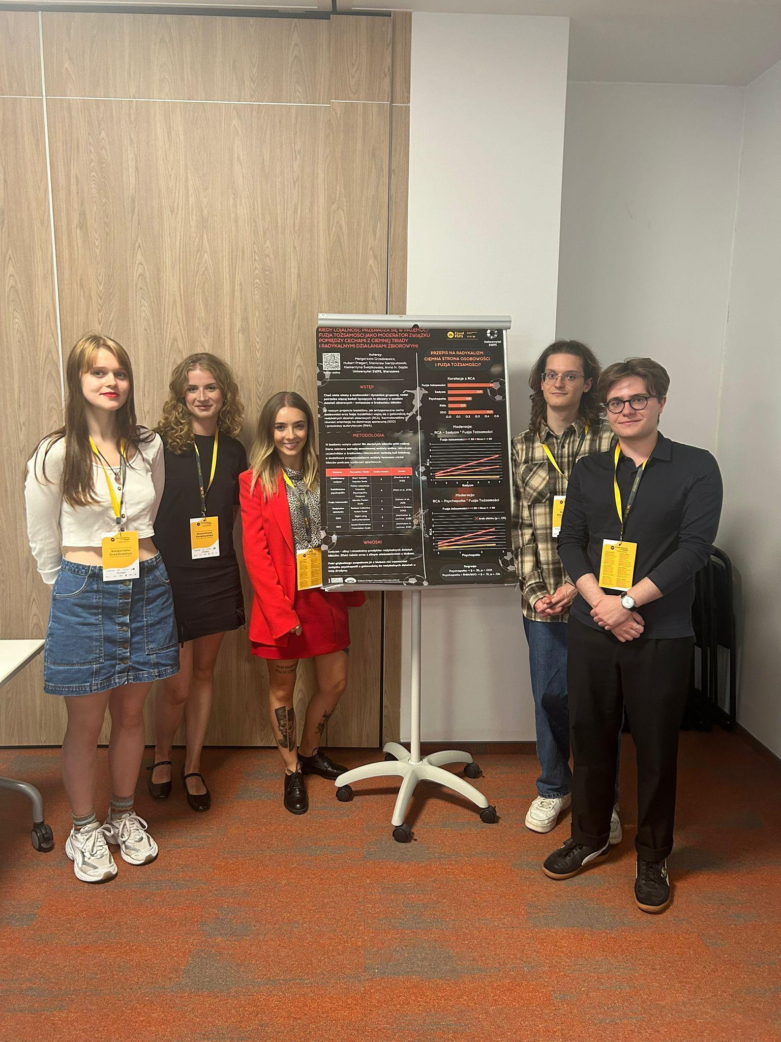 Studenci i studentki USWPS prezentujący plakat naukowy na temat środowiska kibiców piłki nożnej